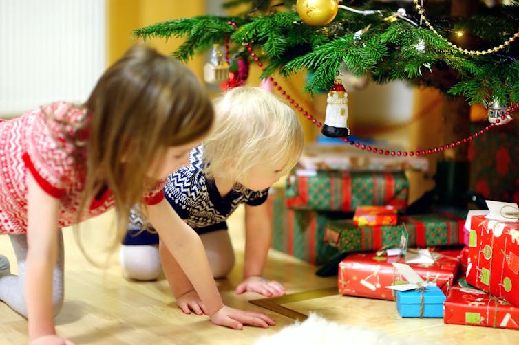 Children looking at presents under the tree