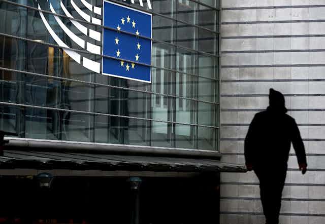 A person walks past the entrance of the European Parliament in Brussels