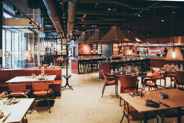 A restaurant dining room with overhead and table-top lighting.