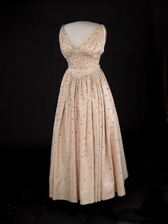 A pale pink peau de soie gown, cinched at the waist, embroidered with more than 2,000 rhinestones shown on a mannequin