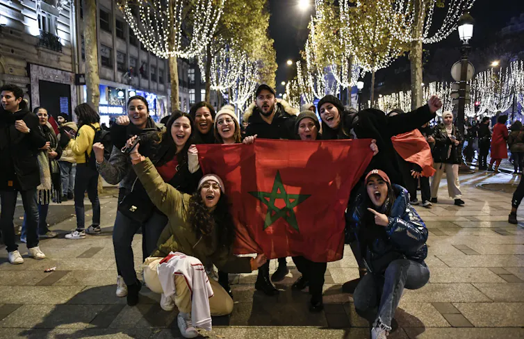 Des supporters de l’équipe marocaine célèbrent la victoire contre le Portugal sur les Champs Elysées à Paris, quelques jours avant le match qui opposera France et Maroc le 14 décembre