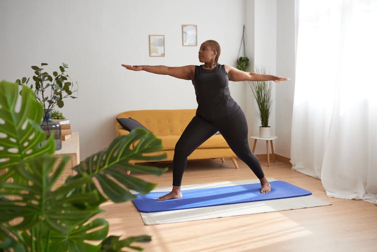woman doing standing pose on yoga mat