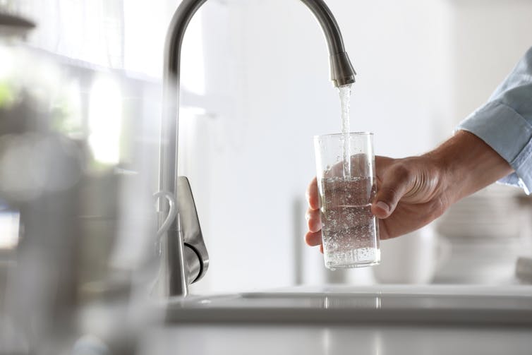 personne se verse un verre d’eau du robinet