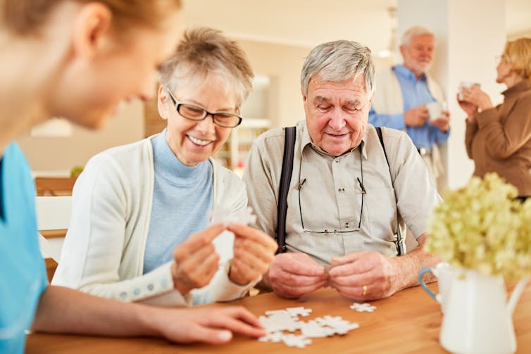 elderly people make a puzzle