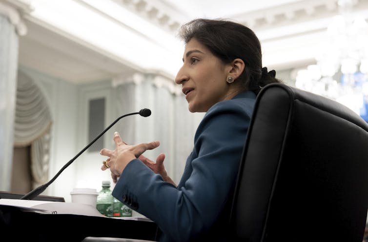 A woman in a suit testifies before a congressional committee.