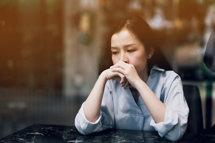 A woman sitting a table looking pensive