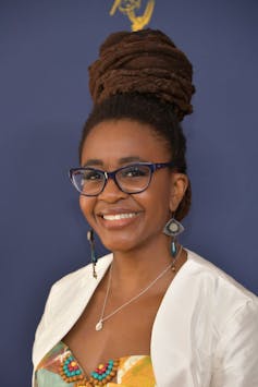 Woman with glasses smiling.