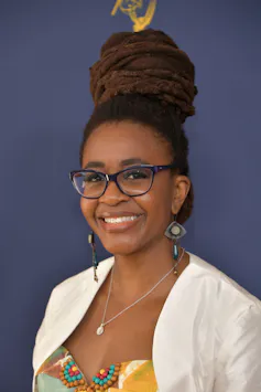 Woman with glasses smiling.