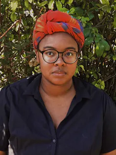 Woman wearing glasses and headscarf.