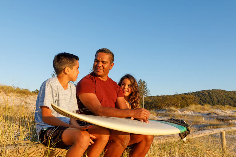 First Nations kids with their dad on the beach