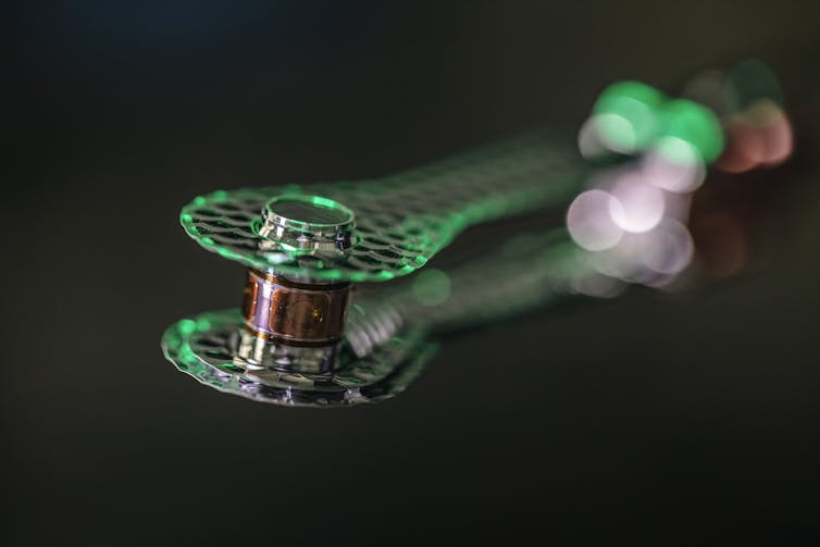 A golden cylinder that looks similar to a sewing machine thread spool