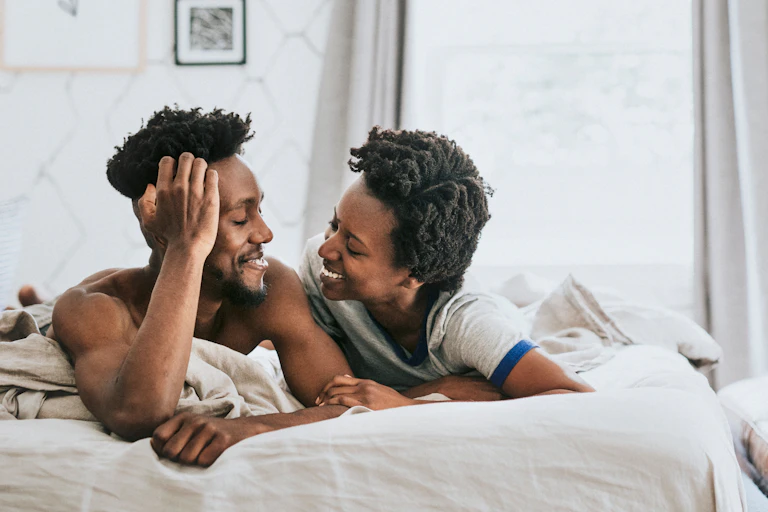 Happy couple talking in bed