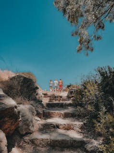 Three young people walk in the bush.