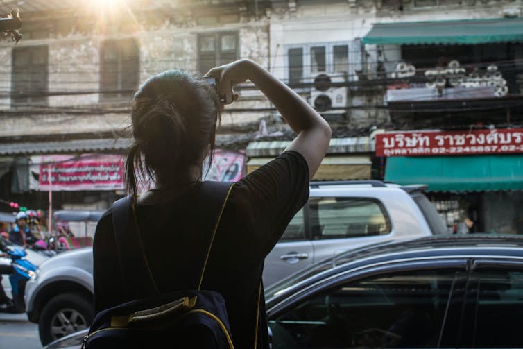 A young woman takes a photograph.