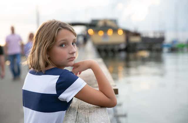 Pre-teen child at a jetty.