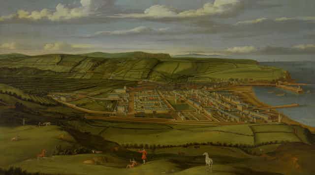 An 18th century painting showing the vista of Whitehaven - then rolling green coastal hills and a sandy beach. 