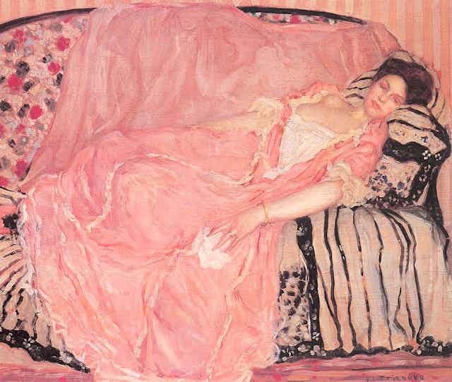 A painting of a young brunette woman lying on a sofa wearing a large pink dress