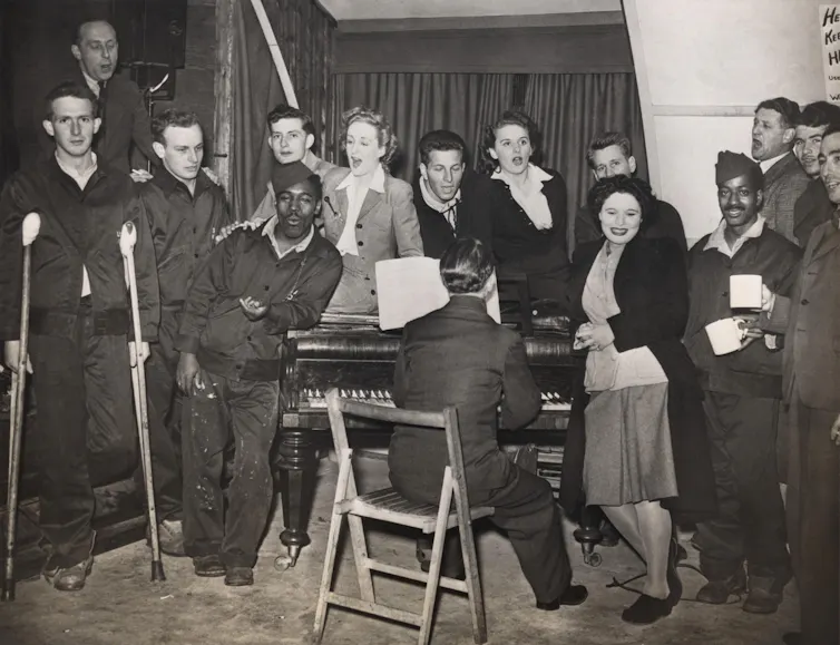 American GIs are entertained by pianist Horatio Davies, at a military hospital in West England.