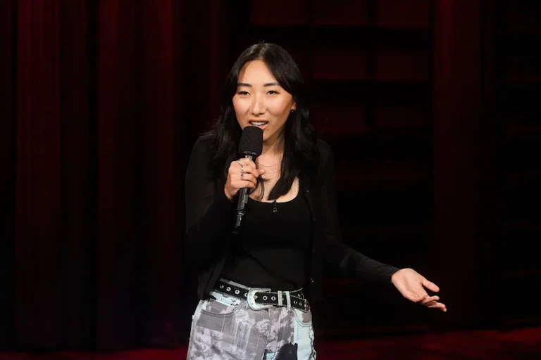 a woman stands with a microphone on stage
