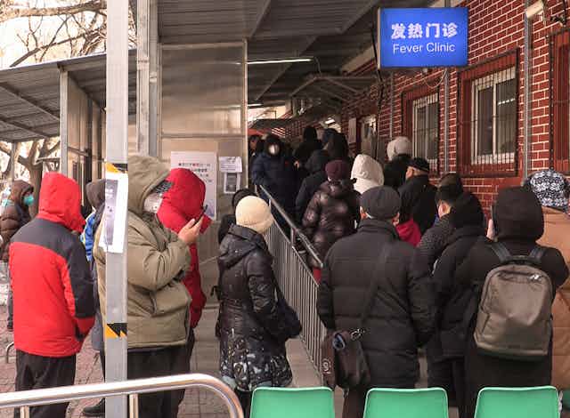 File de personnes faisant la queue devant une clinique à Beijing