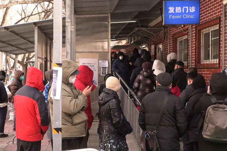 File de personnes faisant la queue devant une clinique à Beijing