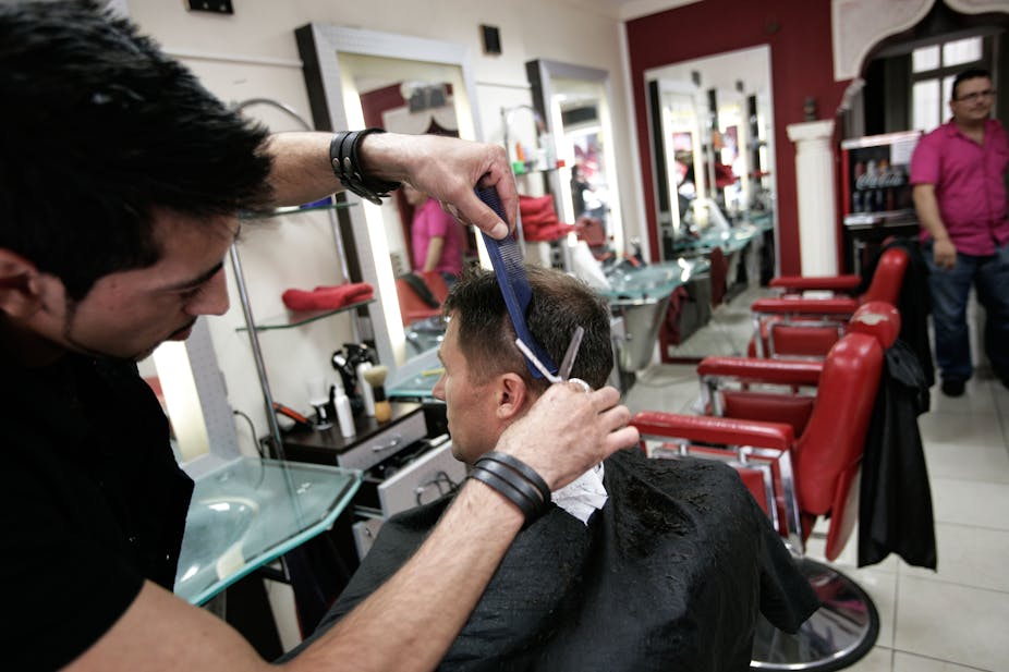 A man cuts another man's hair.