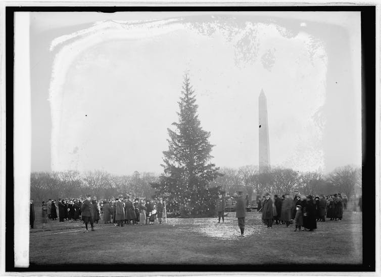 Black and white photo of people gathered around a tall Christmas tree in Washington DC