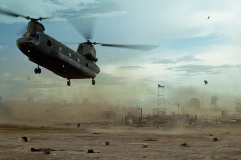 A US helicopter flying over an area of wasteland.