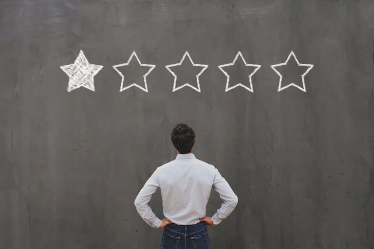 Man staring up at a one-star rating on a chalkboard