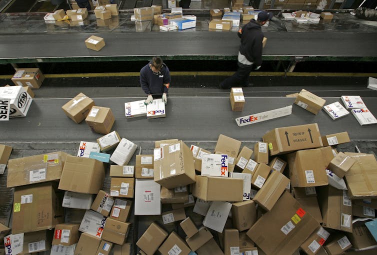 A pile of boxes of various sizes ready for shipping at a FedEx shipping distribution center.