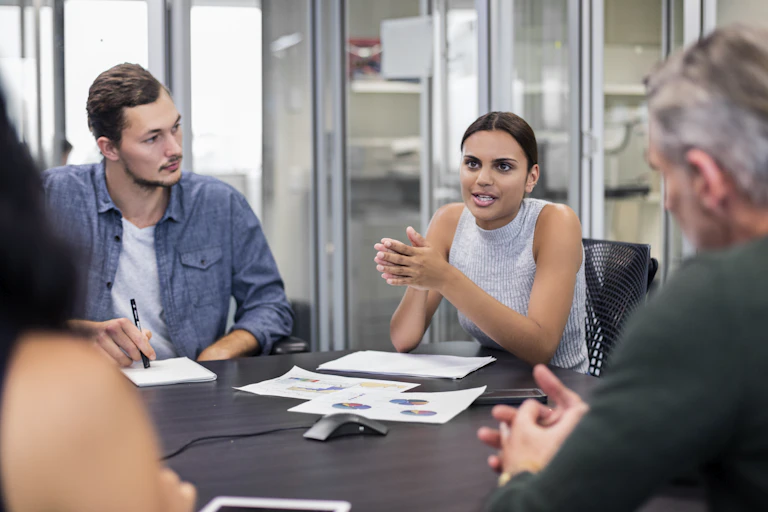 Aboriginal woman explains a concept to her non-Indigenous office colleagues