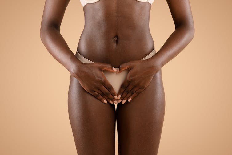 Woman in underwear holding her lower abdomen