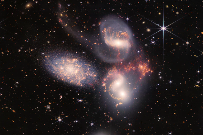 Three spiral galaxies against a backdrop of stars.