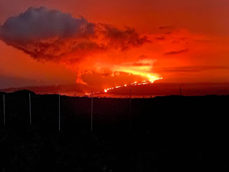 Glowing lava flows from an erupting volcano
