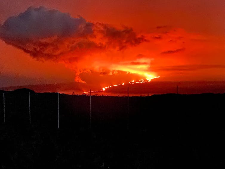 Glowing lava flows from an erupting volcano