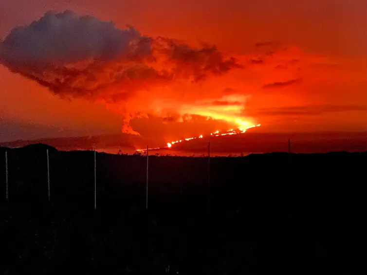 Glowing lava flows from an erupting volcano