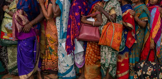 Indian women wait in a queue for a free medical check up camp held to mark Bhim Rao Ambedkar's death anniversary in Mumbai, India, Tuesday, Dec. 6, 2022.