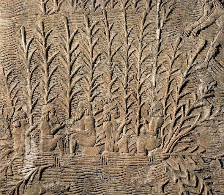 An ancient stone carving showing people in vegetation.