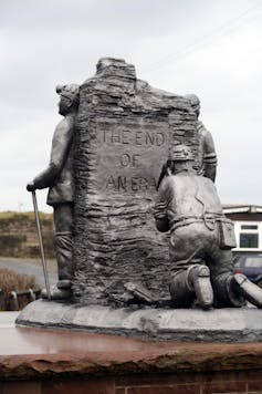 A stone memorial depicting a miner chiselling 'the end of an era'.