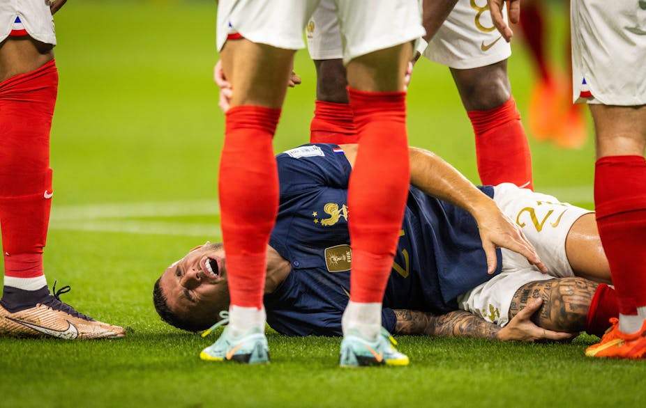 A footballer on the floor in pain. 