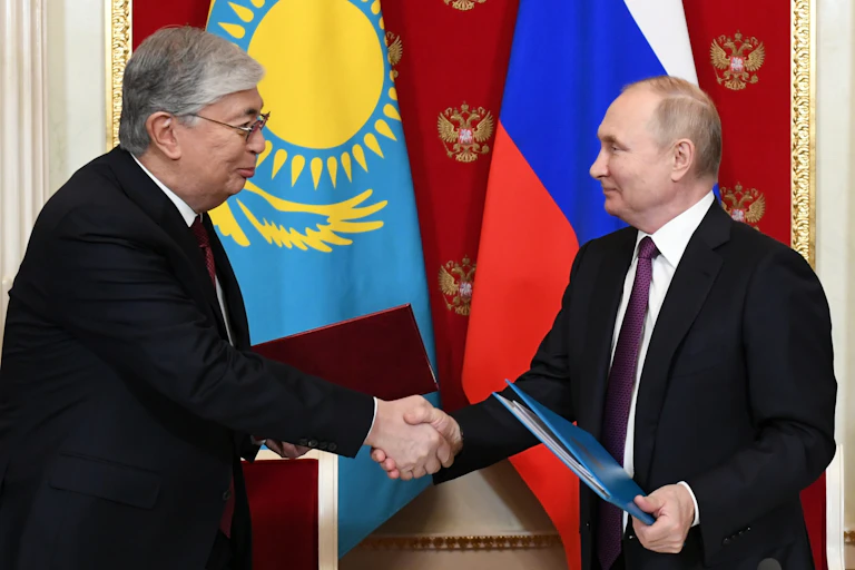 Kazakhstan president Kassym-Jomart Tokayev shakes hands with Russian president Vladimir Putin.
