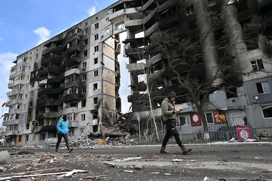 Des personnes passent devant des bâtiments détruits dans la ville de Borodianka, au nord-ouest de Kiev, en Ukraine, le 4 avril 2022. 