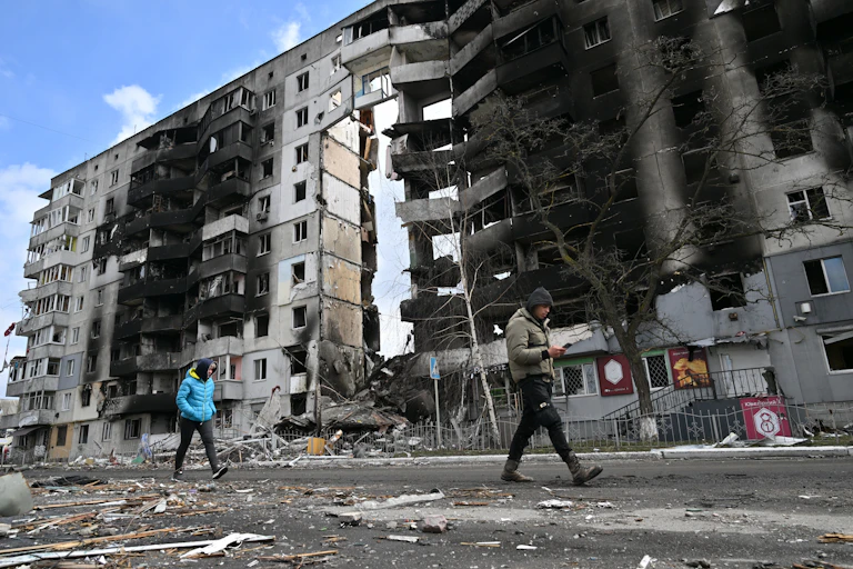 Des personnes passent devant des bâtiments détruits dans la ville de Borodianka, au nord-ouest de Kiev, en Ukraine, le 4 avril 2022.
