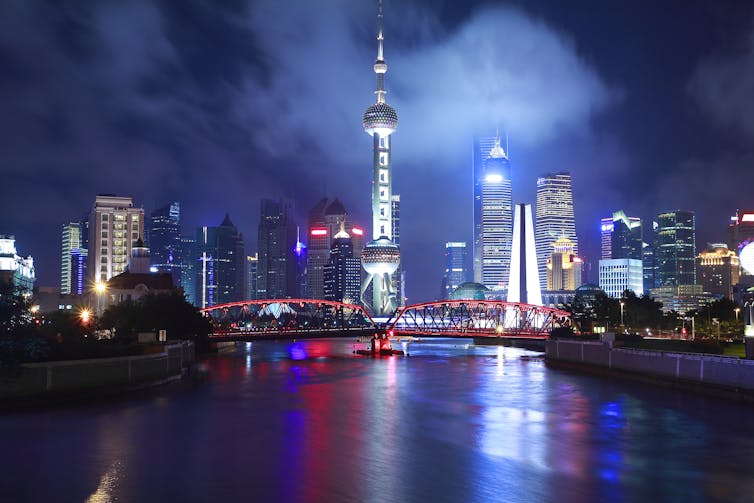 Horizonte de Xangai à noite do mar.