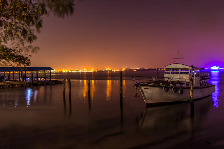 The nighttime sky lit up by artificial lighting illuminating the sea.
