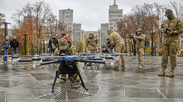 Ukranian soldiers demonstrate some drones in a public square in Kharkiv.