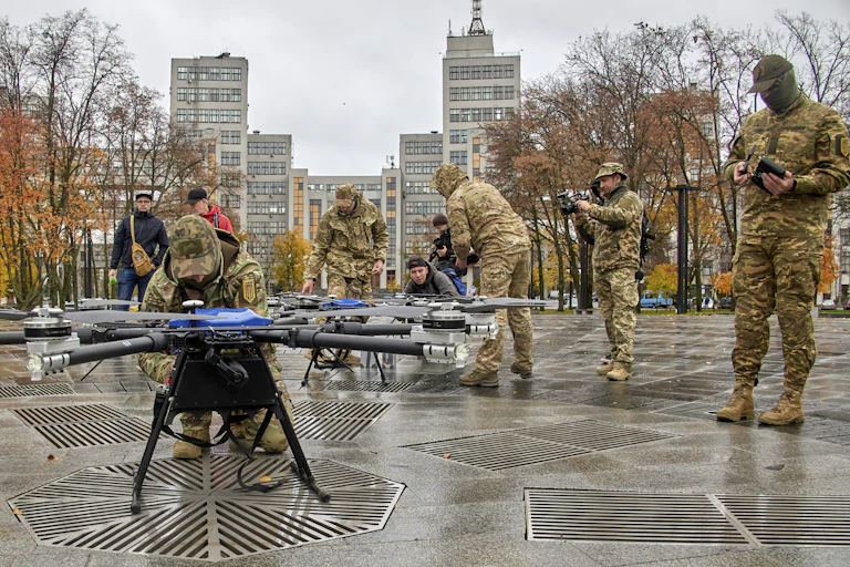 Ukranian soldiers demonstrate some drones in a public square in Kharkiv.