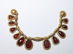 Large garnet pendants on a gold necklace.