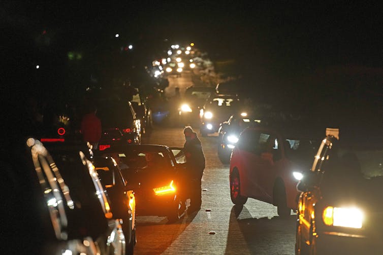 Cars parked on either side of a road at night time