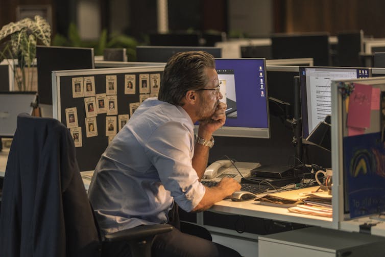 A policeman at a computer.